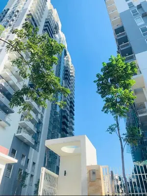 a building with a tree in front of tall buildings at Your Crib - kasara -19 D tower 1 in Manila