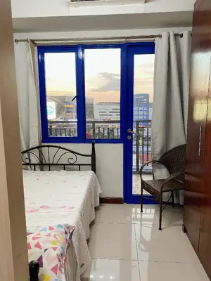 a bedroom with a bed and a window at Azenith Staycation At Sea Residences Moa in Manila