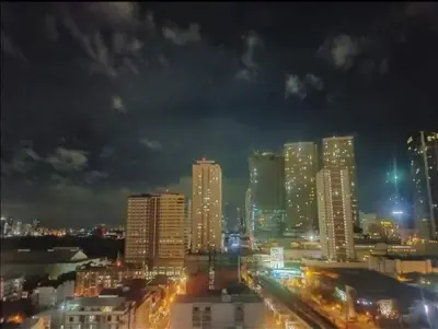 a city lit up at night with tall buildings at Mack's Awesome Place 11 with Netflix and FastUnliwifi in Manila