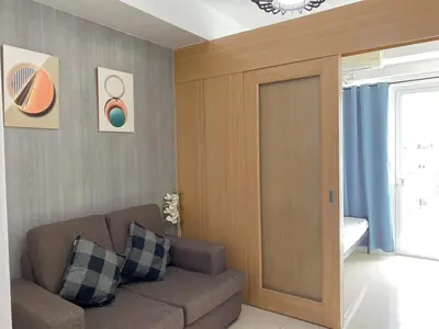 a living room with a couch and a sliding door at SHELL RESIDENCE C6 shortwalk MALL OF ASIA in Manila