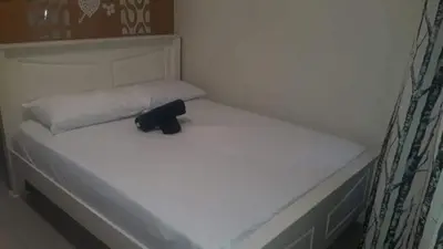 a white bed with a black object on it at SHELL RESIDENCE c5, shortwalk MALL OF ASIA near Airport in Manila