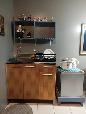 a kitchen with a sink and a stove at Chichi's Snug Pad near Enchanted Kingdom and Nuvali in Santa Rosa