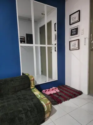 a living room with a couch and a mirror at Chichi's Snug Pad near Enchanted Kingdom and Nuvali in Santa Rosa