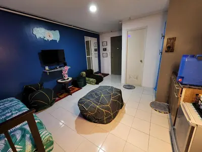 a living room with a blue wall at Chichi's Snug Pad near Enchanted Kingdom and Nuvali in Santa Rosa