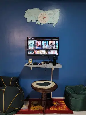 a room with a tv on a blue wall with a stool at Chichi's Snug Pad near Enchanted Kingdom and Nuvali in Santa Rosa
