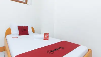 a room with two beds with a red towel on it at RedDoorz @ Malibu Room BF International Las Pinas in Manila