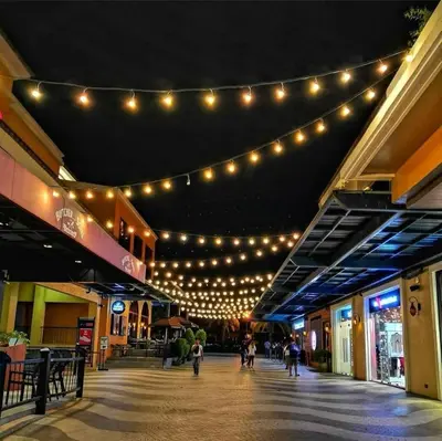 a shopping mall with lights and people walking through it at RedDoorz @ Malibu Room BF International Las Pinas in Manila