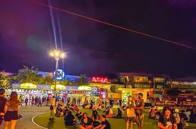 a crowd of people sitting on the street at night at SHELL RESIDENCE c4 shortwalk Mall of Asia near airport in Manila