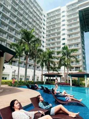 a group of people laying in chairs in a swimming pool at SHELL RESIDENCE c4 shortwalk Mall of Asia near airport in Manila