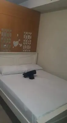 a large white bed with a black object on it at SHELL RESIDENCE c4 shortwalk Mall of Asia near airport in Manila