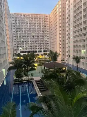 a view of a large building with a pool and palm trees at SHELL RESIDENCE c4 shortwalk Mall of Asia near airport in Manila