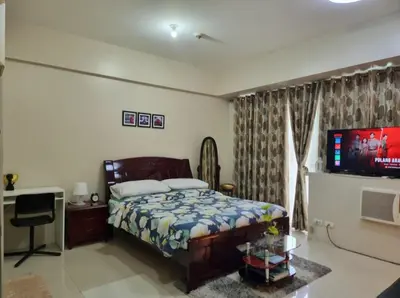 a bedroom with a bed and a flat screen tv at One Palm Tree Villas Condo Across NAIA Terminal 3 in Manila