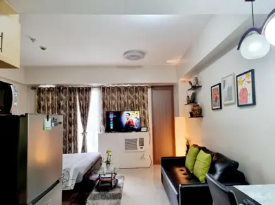 a living room with a couch and a tv at One Palm Tree Villas Condo Across NAIA Terminal 3 in Manila