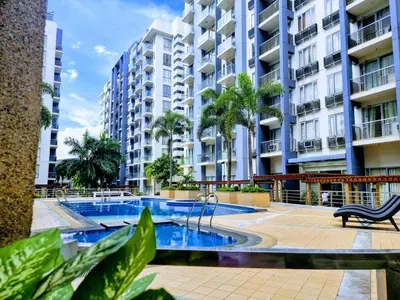 a swimming pool in front of a apartment building at One Palm Tree Villas Condo Across NAIA Terminal 3 in Manila