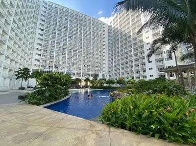 a large building with a swimming pool in front of it at Cozy Space at Shore Residences in Tower D in Manila