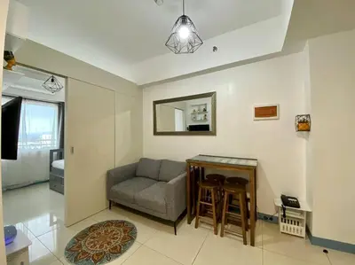a living room with a couch and a table at A Cozy 2 Bedroom Unit with a Parking at South Residences SM Southmall in Manila