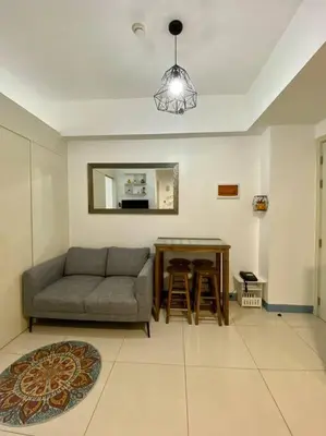 a living room with a couch and a table at A Cozy 2 Bedroom Unit with a Parking at South Residences SM Southmall in Manila