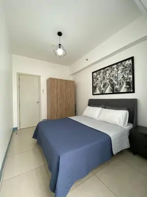 a bedroom with a large blue bed in a room at A Cozy 2 Bedroom Unit with a Parking at South Residences SM Southmall in Manila
