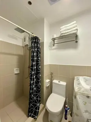 a small bathroom with a toilet and a shower at A Cozy 2 Bedroom Unit with a Parking at South Residences SM Southmall in Manila