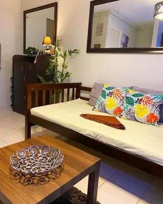 a room with a bed and a table and a mirror at Cozy Boo Bed and Breakfast near Enchanted Kingdom by Dynel in Santa Rosa
