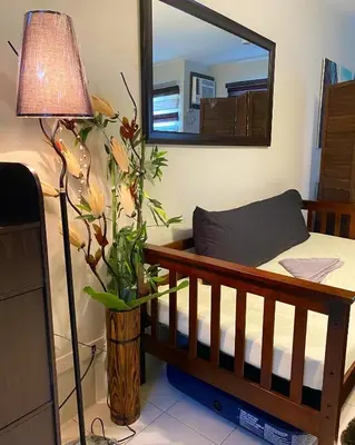 a bedroom with a crib and a mirror and a lamp at Cozy Boo Bed and Breakfast near Enchanted Kingdom by Dynel in Santa Rosa