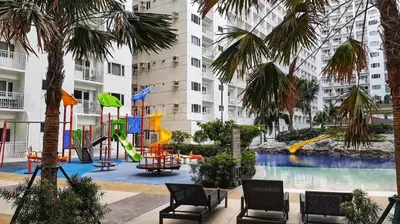 a playground in the middle of a building with palm trees at SHELL RESIDENCE c3 shortwalk mall of asia near airport in Manila