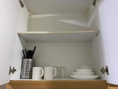 a shelf with cups and plates and utensils at SHELL RESIDENCE c3 shortwalk mall of asia near airport in Manila