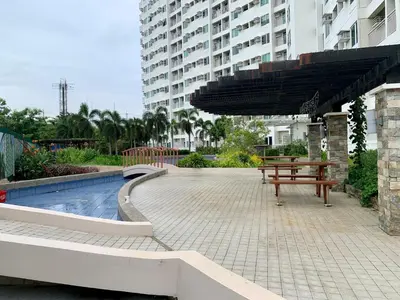 a picnic table and an umbrella next to a pool at At Home Condo With Free Pool Access in Manila