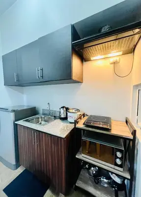 a small kitchen with a sink and a counter at At Home Condo With Free Pool Access in Manila