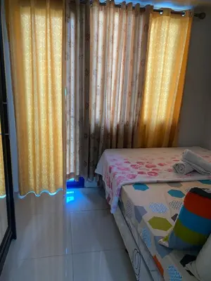 a bedroom with yellow curtains and a bed in a room at Madison's Place at Sea MOA in Manila