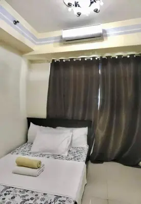 a bedroom with a bed with a black curtain at Madison's Place at Sea MOA in Manila