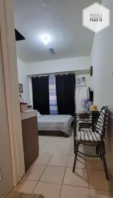 a bedroom with a bed and a table and a chair at Mack's Awesome 15 with Netflix and FastUnliwifi in Manila