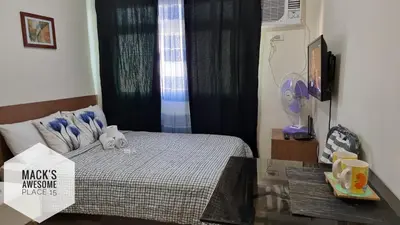 a bedroom with a bed with a table and a window at Mack's Awesome 15 with Netflix and FastUnliwifi in Manila