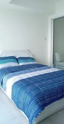 a blue and white bed in a white room at AZURE URBAN RESORT - PARANAQUE MANILA NEAR TERMINAL UNLIMITED WIFI and Netflix in Manila