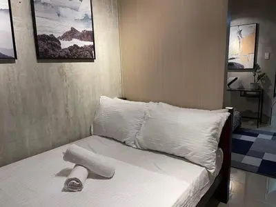 a bed with white sheets and a towel on it at Sea Residences MOA arena SMX by darpm in Manila
