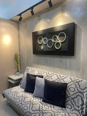 a couch with three olympics on a wall at Sea Residences MOA arena SMX by darpm in Manila
