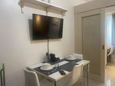 a table with chairs and a television on a wall at Sea Residences MOA arena SMX by darpm in Manila