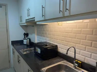 a kitchen with a sink and a toaster on the counter at Sea Residences MOA arena SMX by darpm in Manila
