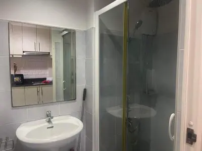 a bathroom with a sink and a shower with a mirror at Sea Residences MOA arena SMX by darpm in Manila