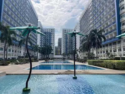 a swimming pool in a city with tall buildings at Sea Residences MOA arena SMX by darpm in Manila