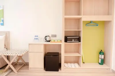 a small kitchen with a shelf with a microwave at Lime Resort Manila in Manila