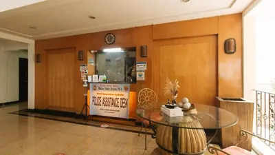 a dining room with a glass table and a clock at Casa Micarosa Hotel and Residences by RedDoorz in Manila