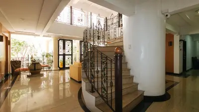 a hallway with a spiral staircase in a house at Casa Micarosa Hotel and Residences by RedDoorz in Manila