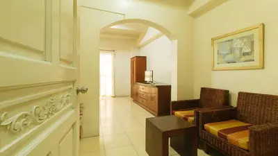 a living room with a chair and a table at Casa Micarosa Hotel and Residences by RedDoorz in Manila