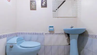 a bathroom with a blue toilet and a sink at JBs Transient House in General Trias