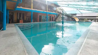 a swimming pool with blue water in a building at Alamaris Resort RedPartner in Rizal