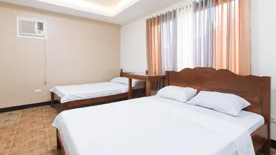 a hotel room with two beds and a window at Alamaris Resort RedPartner in Rizal