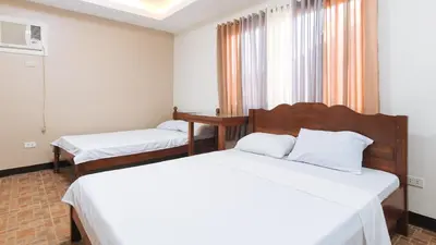 a hotel room with two beds and a window at Alamaris Resort RedPartner in Rizal