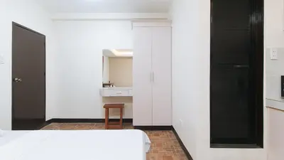 a bedroom with white walls and a black door at Alamaris Resort RedPartner in Rizal