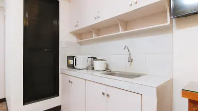 a white kitchen with a sink and a microwave at Alamaris Resort RedPartner in Rizal